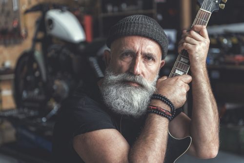 Assured mature man keeping instrument
